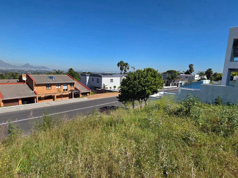 Elevated view overlooking a residential street and surrounding neighborhood with distant mountain vistas.