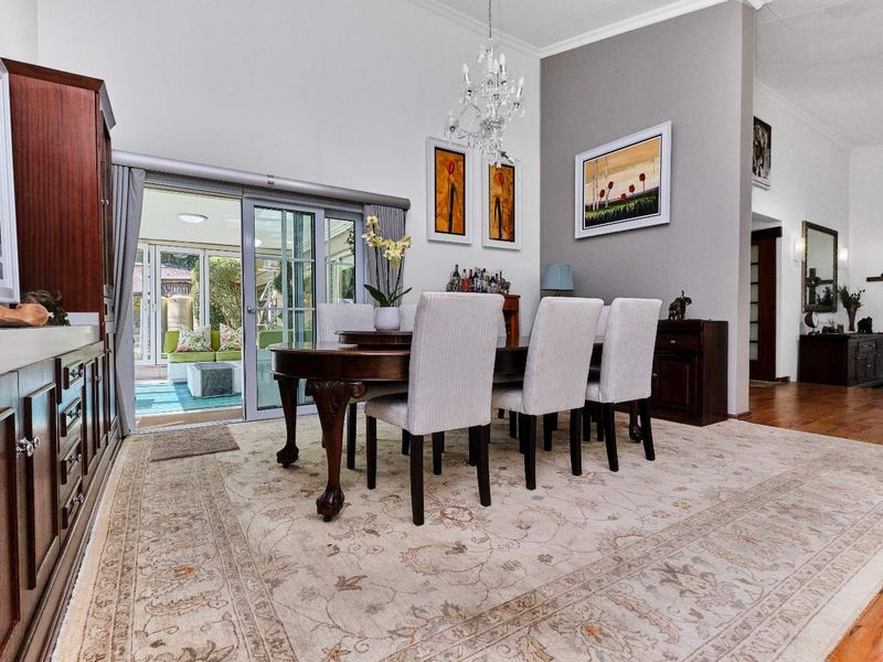 Elegant dining room featuring hardwood floors, built-in cabinetry, and sliding glass doors that open to a bright patio area.