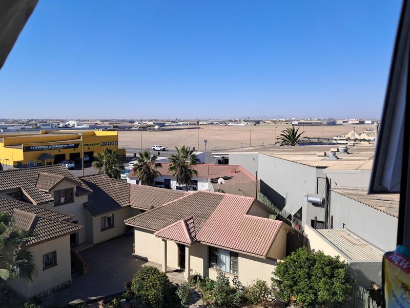 An elevated view overlooking the surrounding neighborhood, nearby commercial buildings, and open landscape.