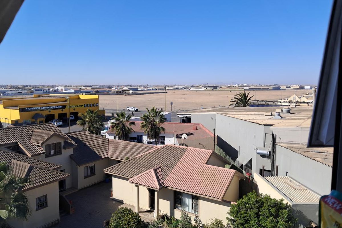 An elevated view overlooking the surrounding neighborhood, nearby commercial buildings, and open landscape.
