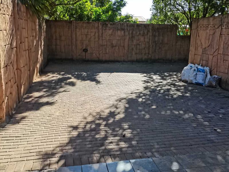 A private paved courtyard area enclosed by textured boundary walls, offering a versatile outdoor space.