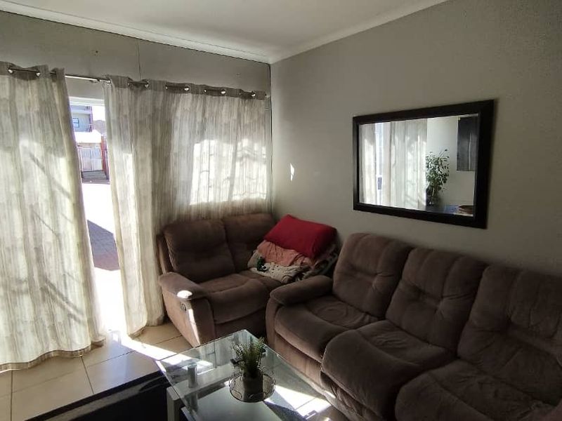 A living room featuring tiled flooring and a sliding glass door providing access to the exterior.