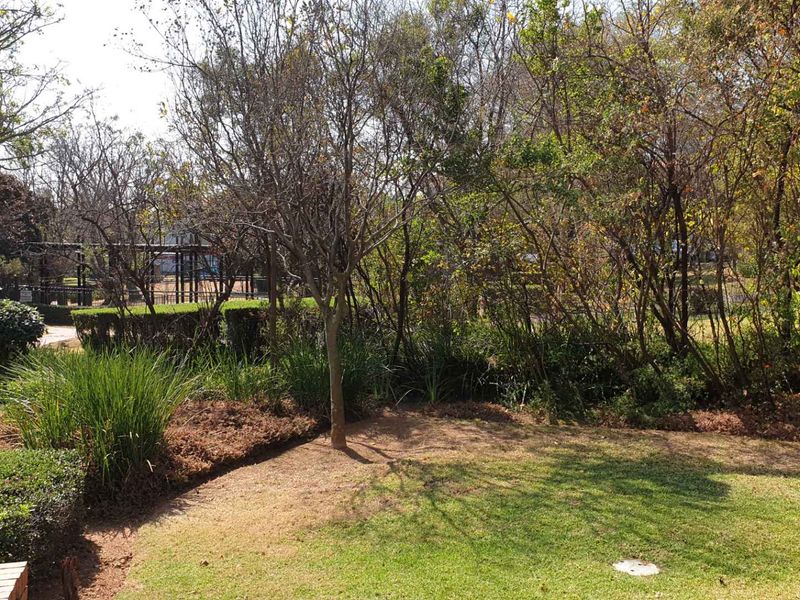A view of a private garden area featuring established trees, shrubs, and a lawn, providing a natural outlook from the property.