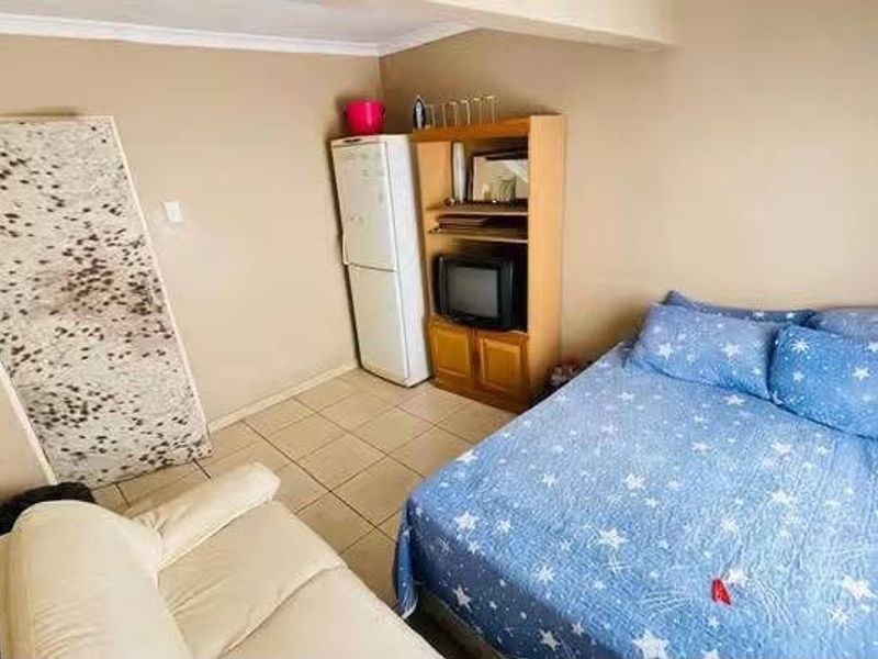 A compact bedroom featuring tiled flooring and neutral wall finishes, providing a functional space for rest.