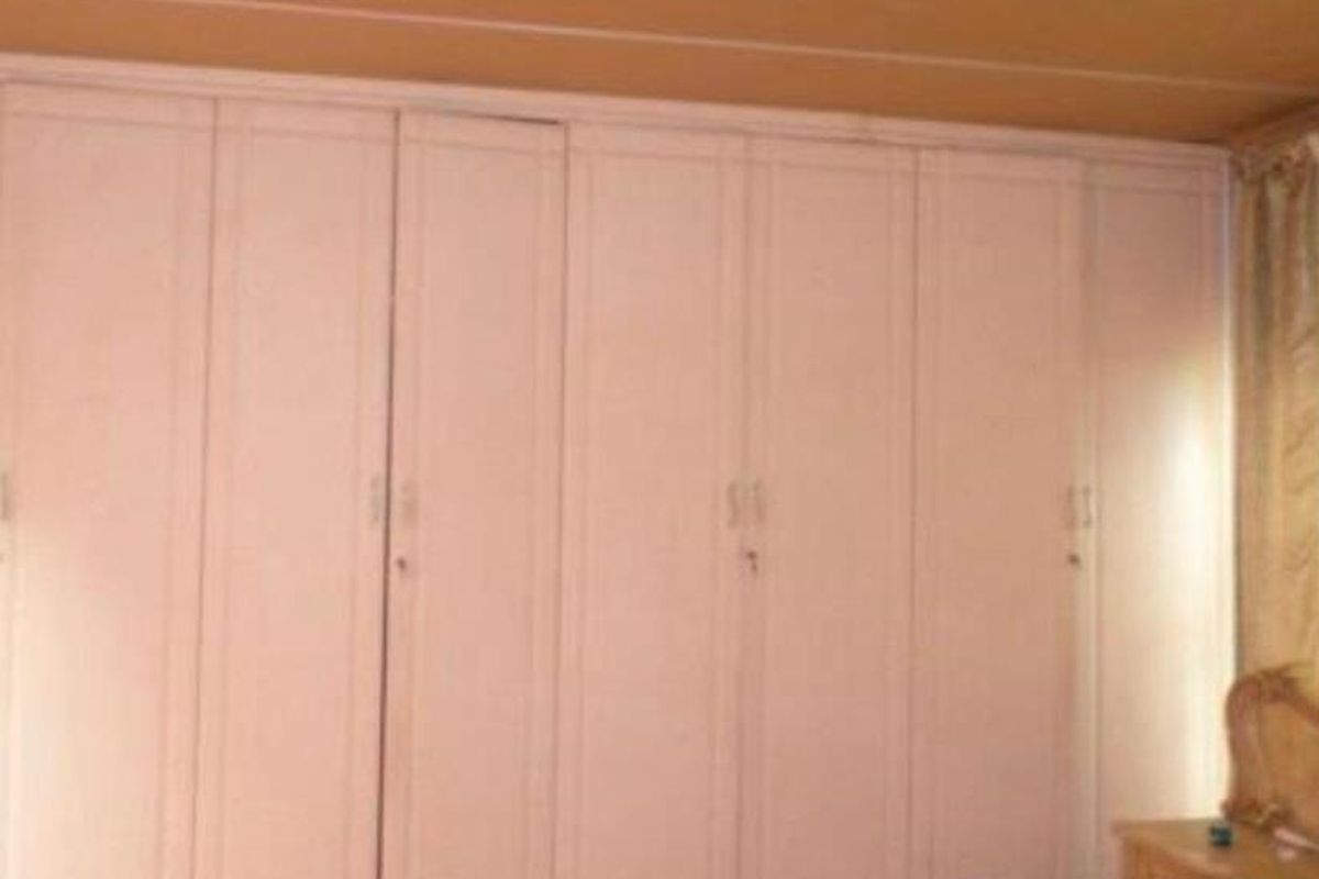 A bedroom featuring extensive floor-to-ceiling built-in cabinetry providing ample storage space.