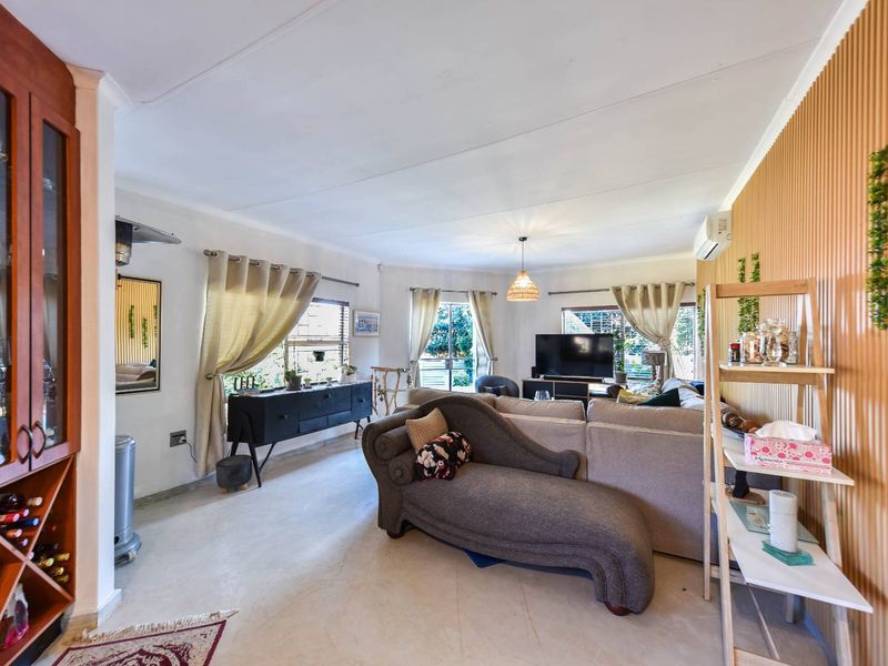 Spacious living room featuring timber slat wall paneling, built-in wine storage, and direct access to the outdoor area through sliding glass doors.