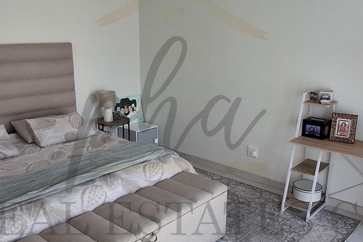 A well-maintained bedroom featuring neutral wall tones and tiled flooring, providing a comfortable and functional living space.