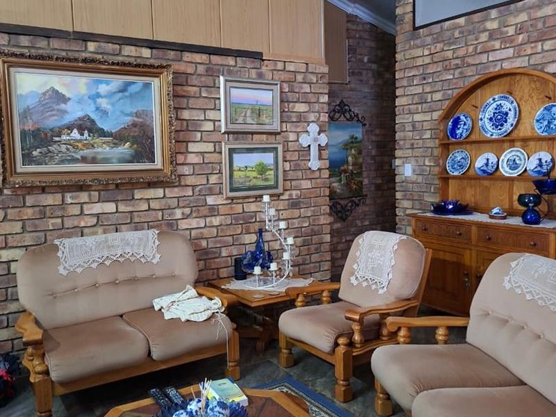 A living room featuring exposed brick walls, timber paneling, and tiled flooring, offering a traditional aesthetic with potential for modern updates.