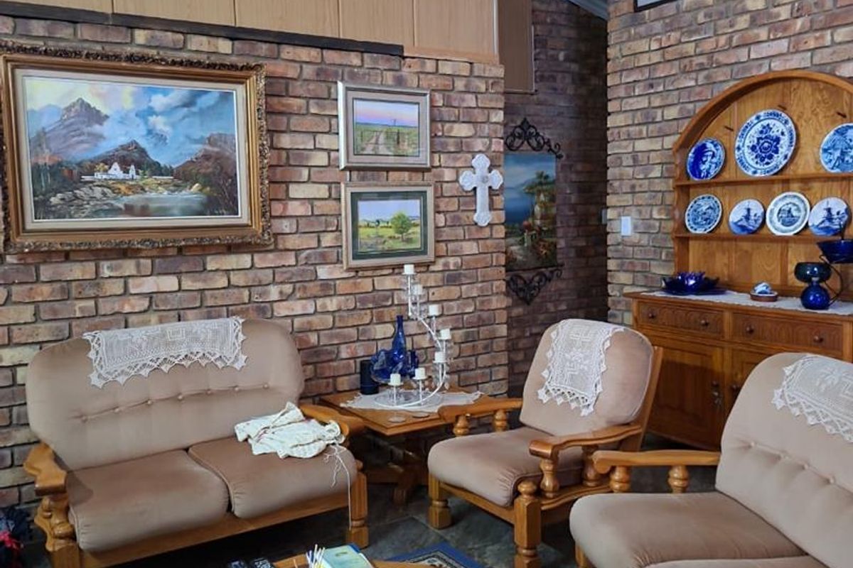 A living room featuring exposed brick walls, timber paneling, and tiled flooring, offering a traditional aesthetic with potential for modern updates.