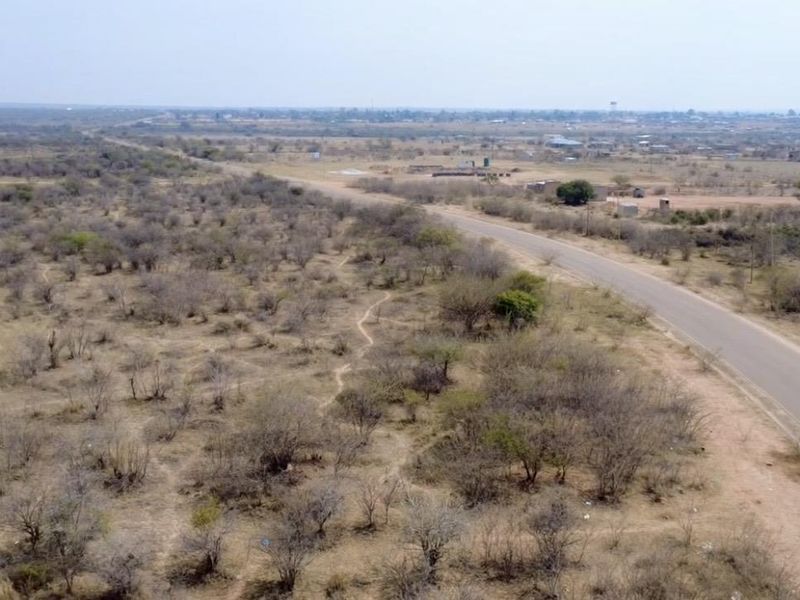 An aerial view of the expansive rural landscape featuring a paved road running through the property.