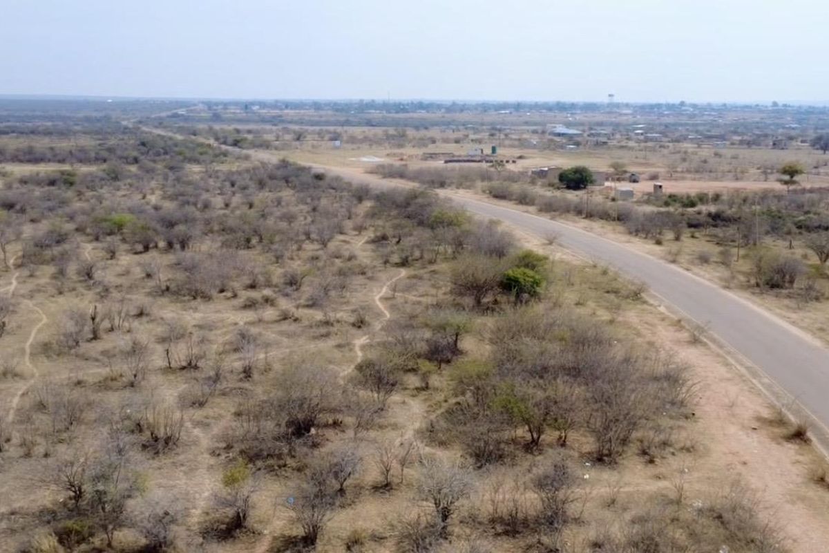 An aerial view of the expansive rural landscape featuring a paved road running through the property.