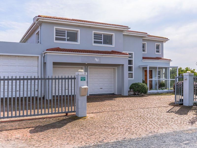 Front elevation of a two-story house featuring a paved driveway, double garage, and an enclosed entrance porch.