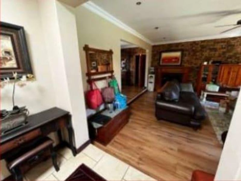 A living room featuring laminate flooring, a brick accent wall, and a fireplace, providing a warm and functional space for relaxation.