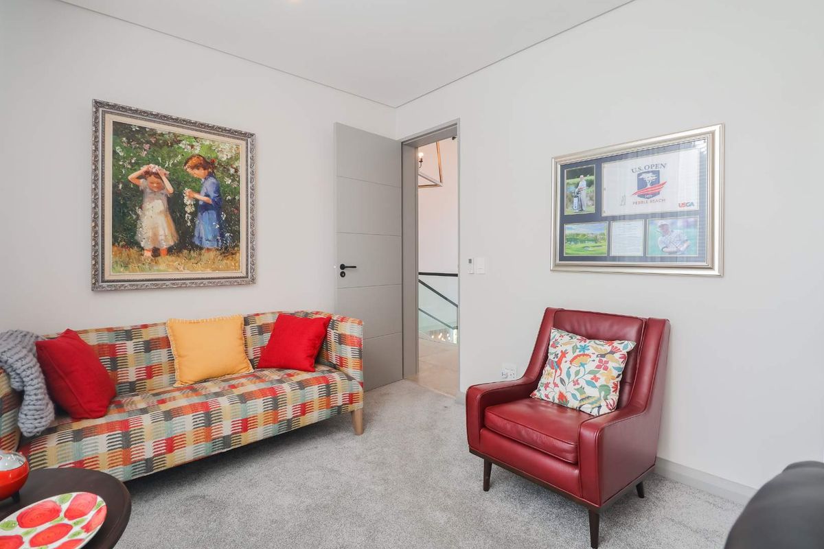 A well-maintained living area featuring neutral carpeting, clean white walls, and a modern grey internal door leading to the hallway.
