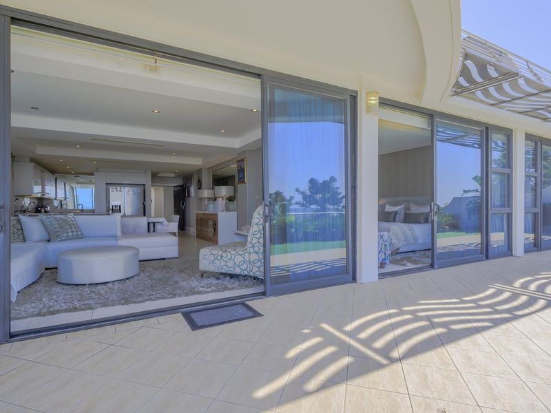 Spacious covered patio featuring tiled flooring and large sliding glass doors providing seamless indoor-outdoor flow to the living and bedroom areas.