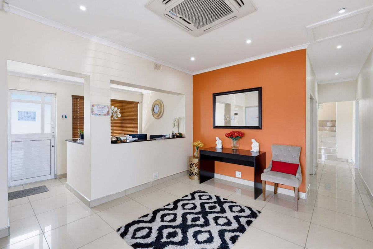 A professional office reception area featuring a built-in service counter, tiled flooring, and integrated ceiling air conditioning.
