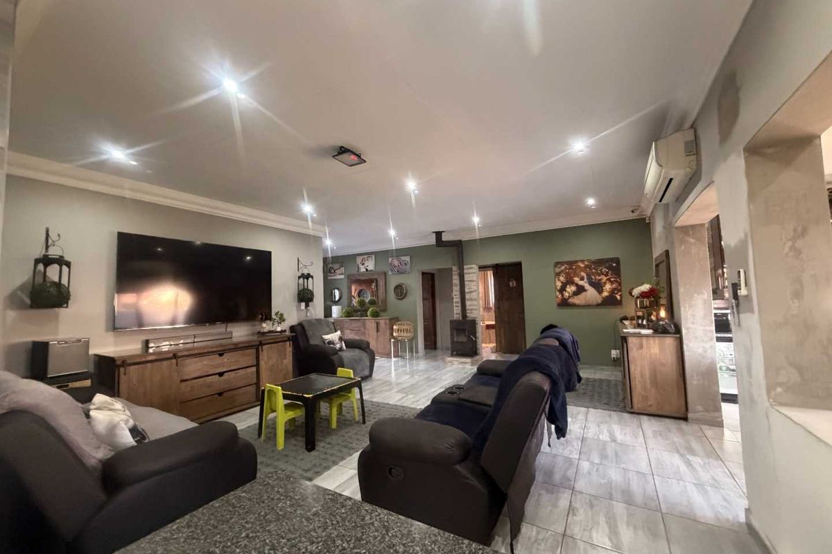 Spacious living room featuring tiled flooring, a wood-burning fireplace, and recessed lighting, with some areas requiring final wall finishing.