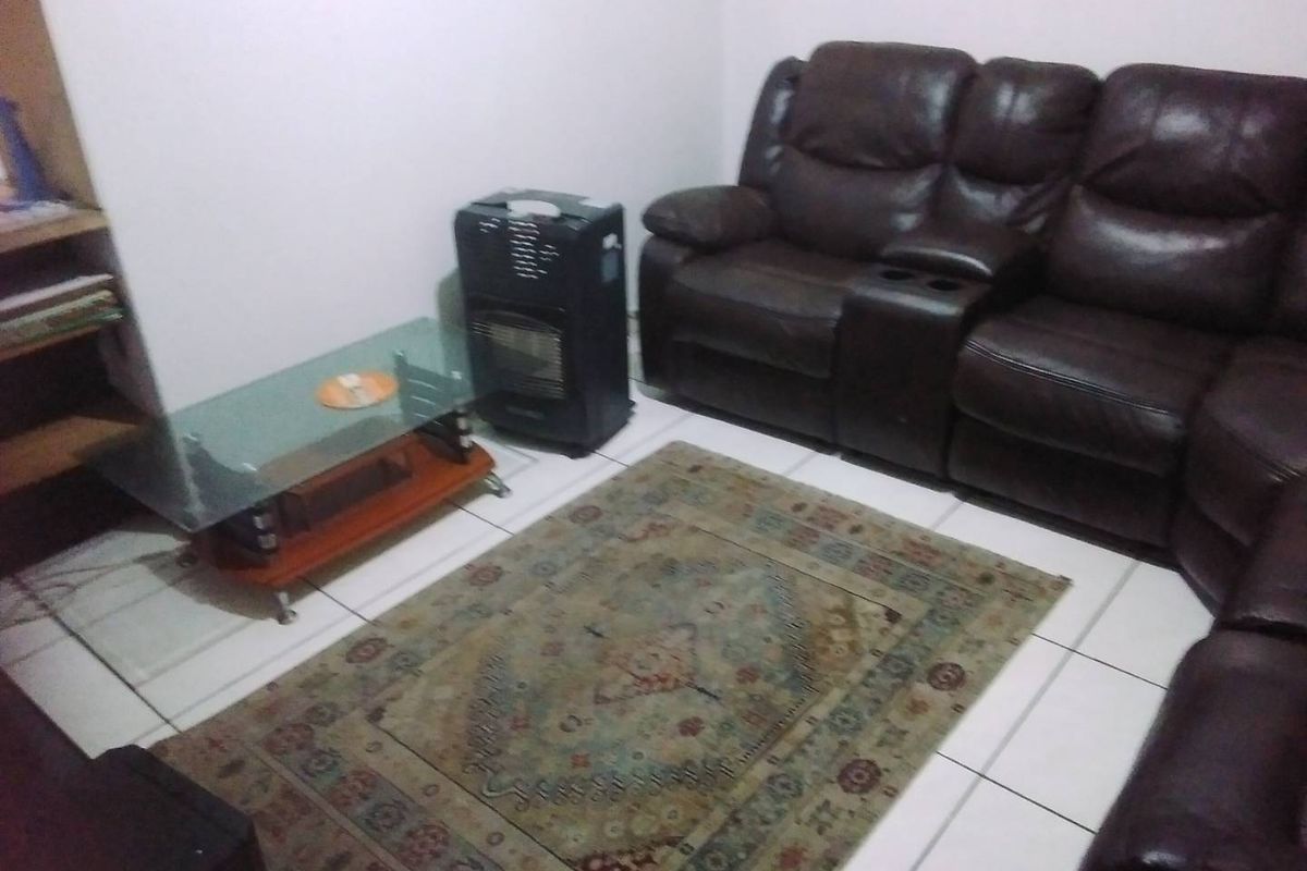 A living room area featuring tiled flooring, providing a functional space for relaxation.