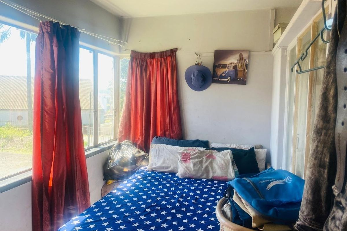 A compact bedroom featuring large windows that provide natural light and a built-in wardrobe for storage.