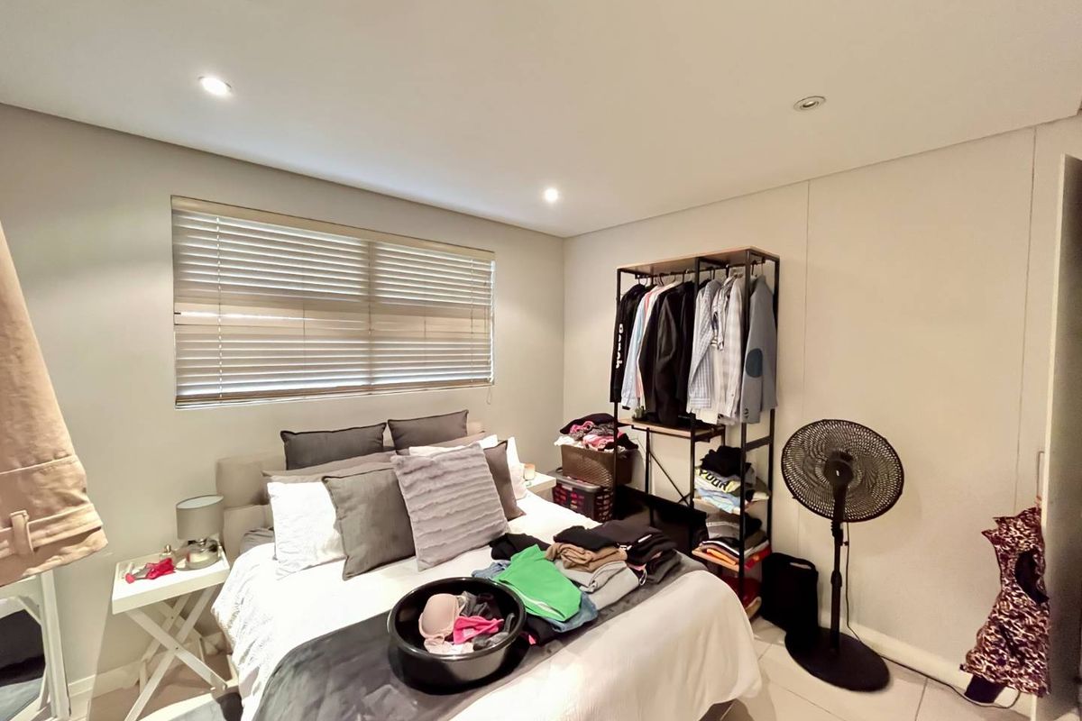 A bedroom featuring tiled flooring, recessed ceiling lighting, and fitted venetian blinds.