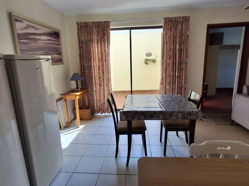 Open plan dining area featuring tiled flooring and a sliding glass door providing access to an outdoor patio space.