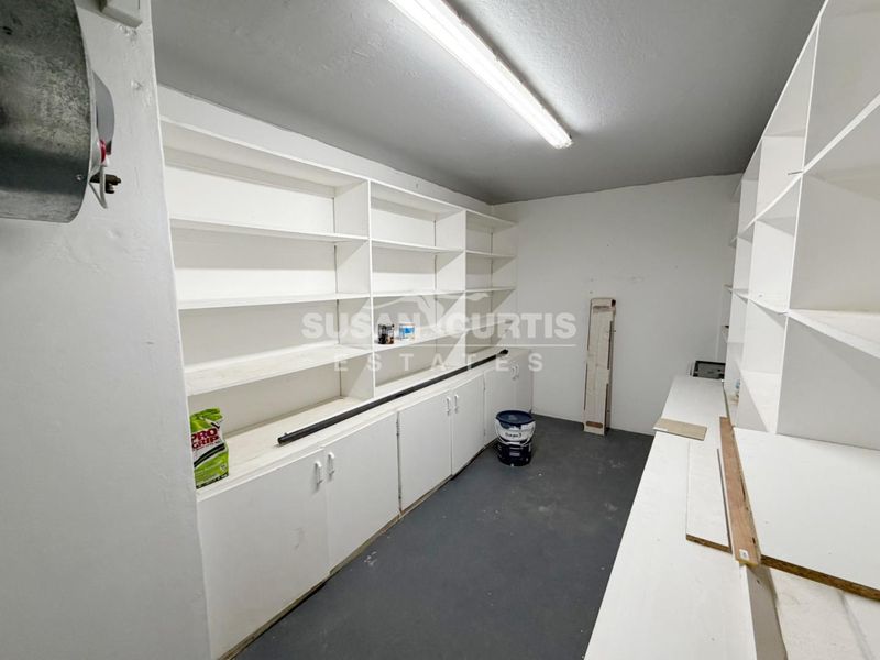 A functional utility or storage room featuring extensive built-in shelving and cabinetry, providing ample storage space for household organization.