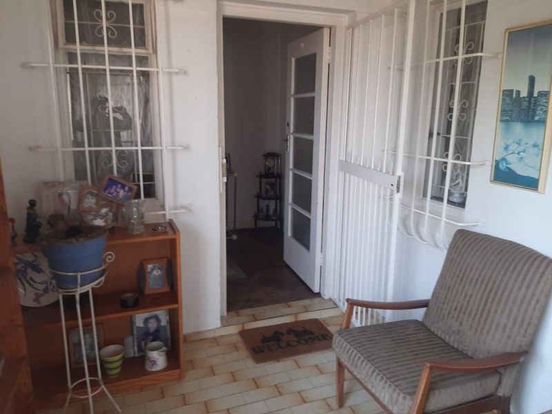 Entrance area featuring tiled flooring, security gates on windows, and a multi-pane glass door leading into the home.