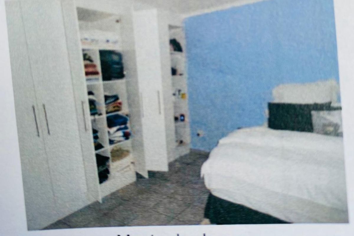 A bedroom featuring built-in white cabinetry with open shelving and tiled flooring.