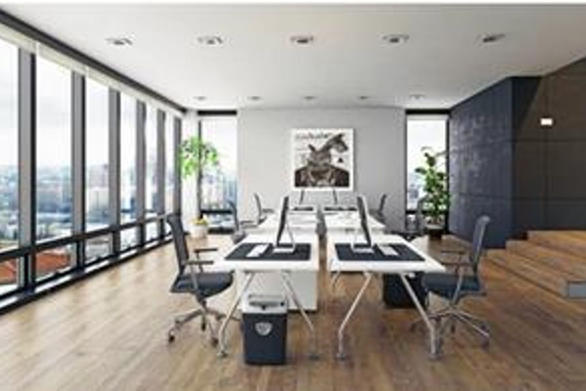 Modern open-plan office space featuring floor-to-ceiling windows, hardwood flooring, recessed lighting, and a raised platform area with a contemporary aesthetic.
