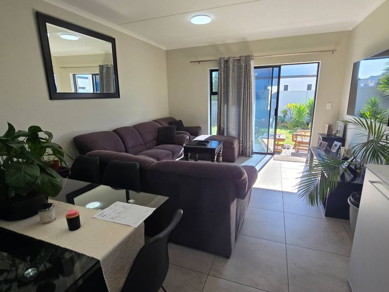 An open-plan living area featuring tiled flooring and a sliding glass door that provides direct access to the outdoor space.