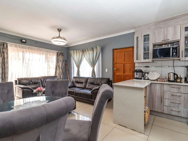 Open-plan living and kitchen area featuring tiled flooring, modern cabinetry, and a functional layout connecting the dining and lounge spaces.