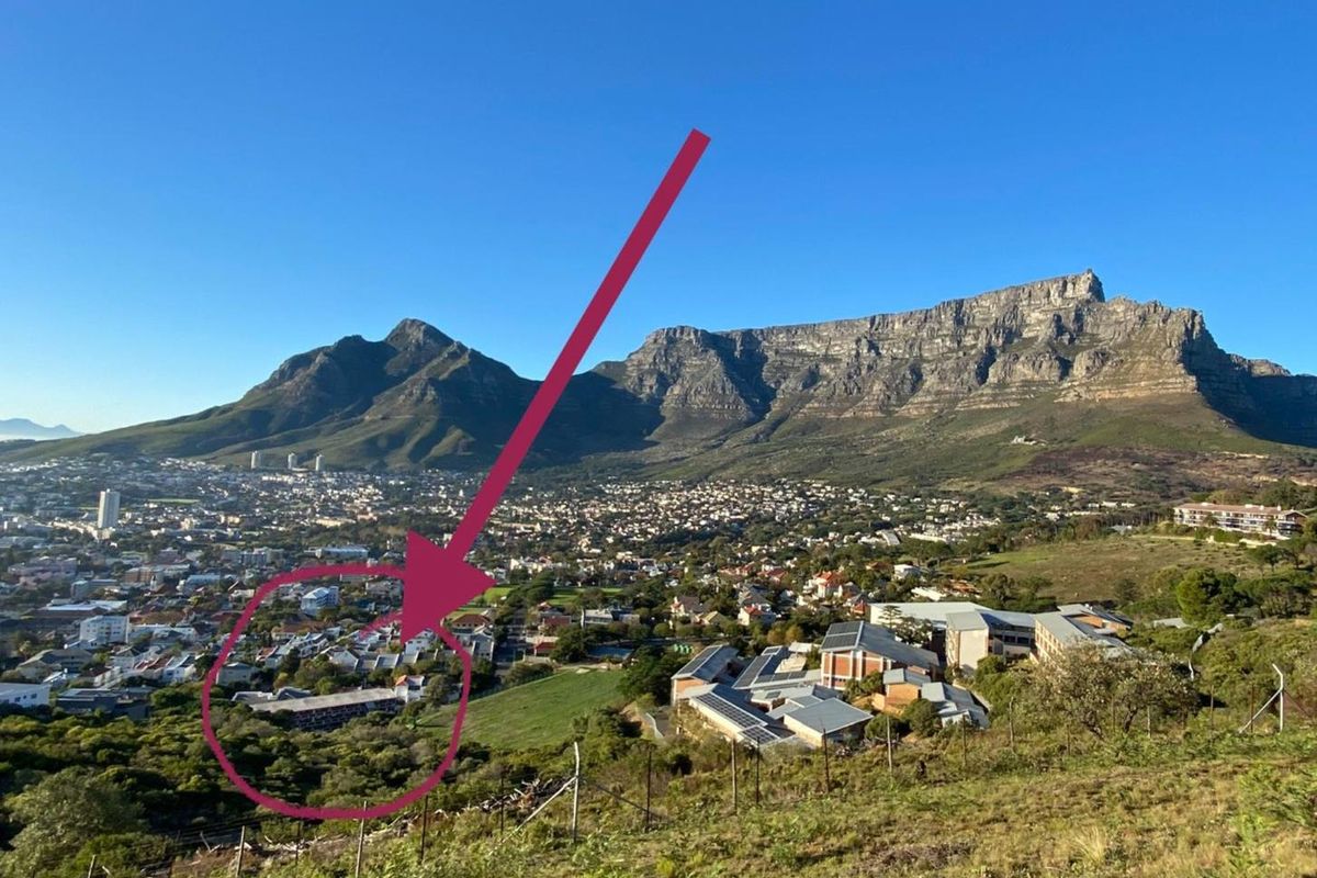 An elevated aerial view showing the surrounding neighbourhood and landscape with a highlighted property location.