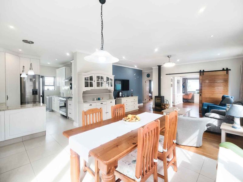 Spacious open-plan living area featuring a modern kitchen with granite countertops, a cozy fireplace, and a stylish sliding barn door connecting to adjacent rooms.