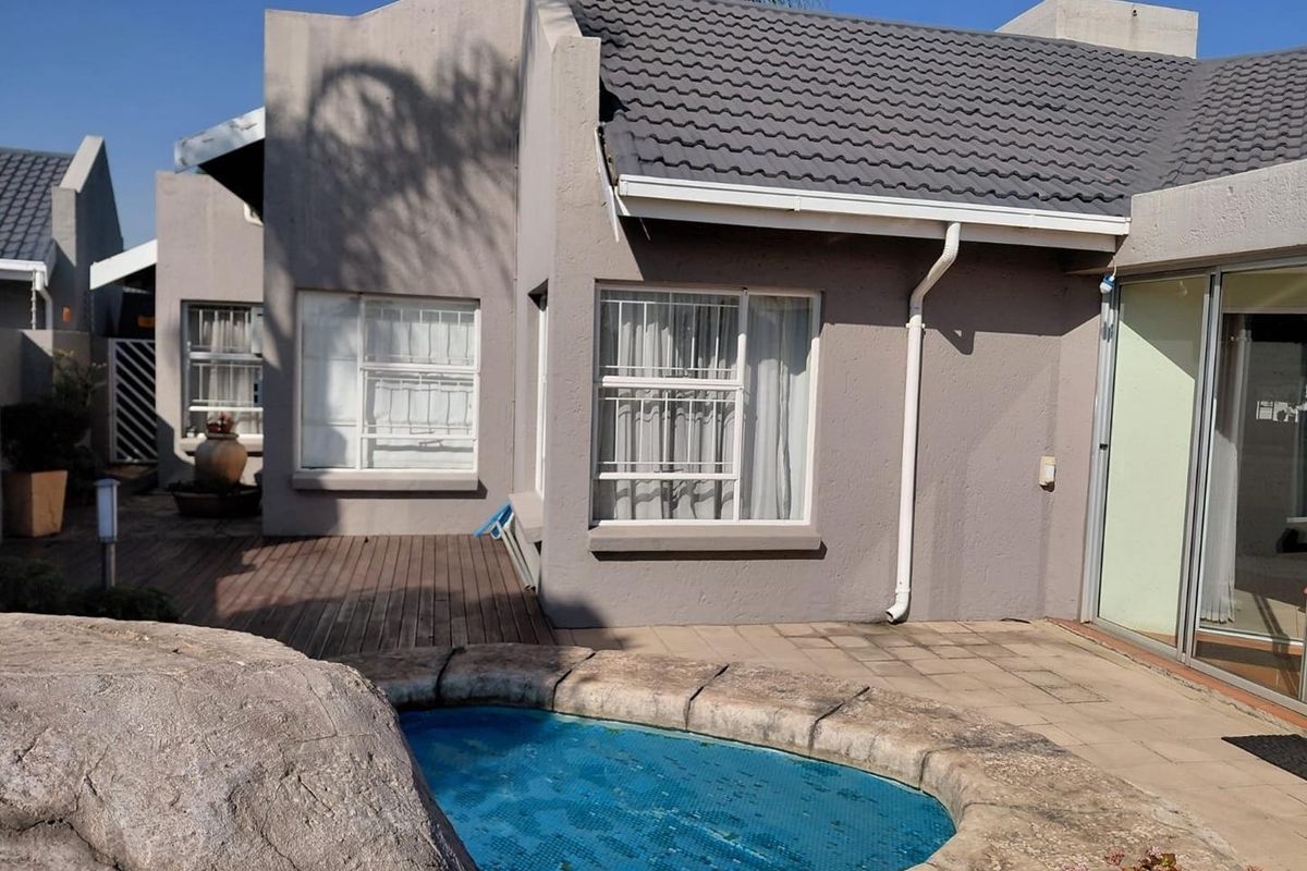 Rear exterior view of the townhouse featuring a plunge pool, timber decking, paved patio area, and sliding glass doors leading to the interior.
