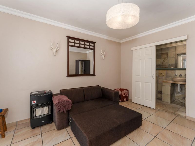 A bedroom featuring tiled flooring, coving, and direct access to an en-suite bathroom through a sliding door.