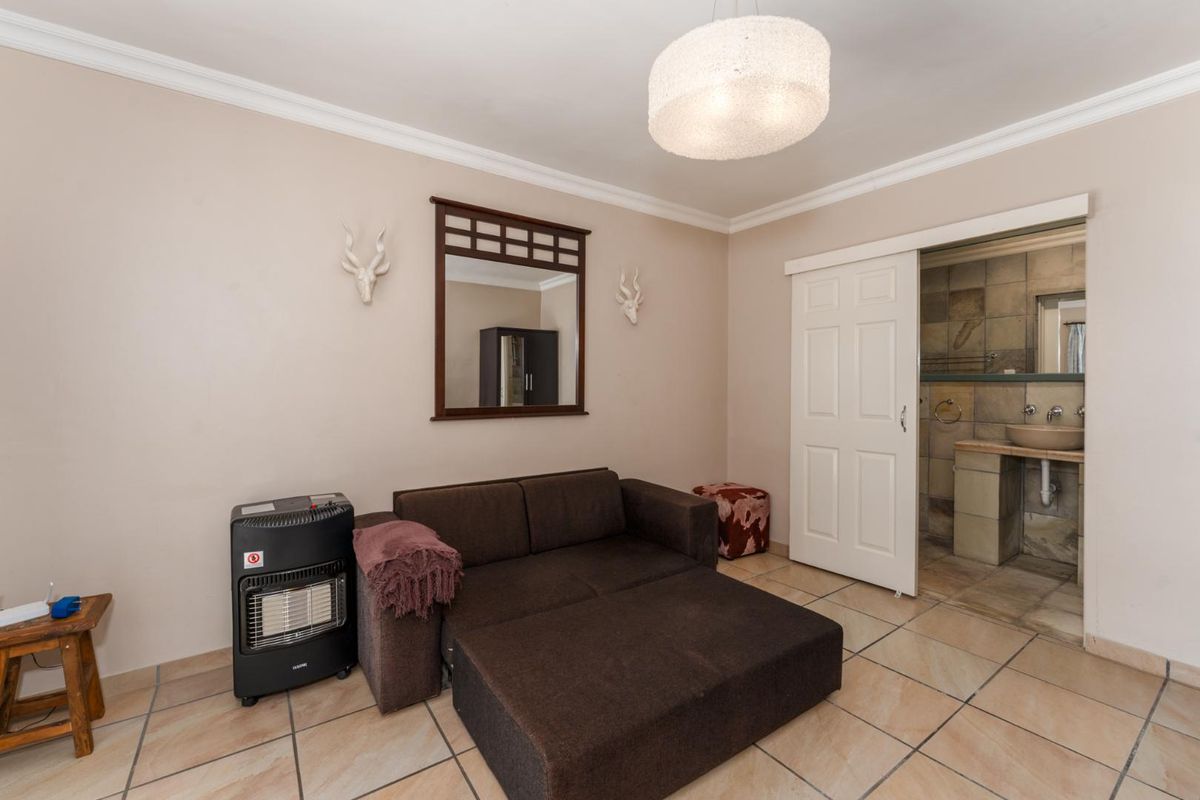A bedroom featuring tiled flooring, coving, and direct access to an en-suite bathroom through a sliding door.
