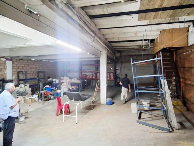 Spacious industrial utility area featuring exposed timber ceiling beams, concrete flooring, and structural support columns, currently undergoing renovation or maintenance.