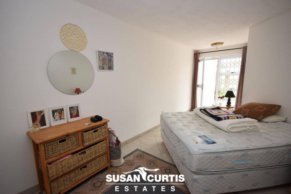 A bedroom featuring tiled flooring and a sliding door with a security gate providing access to the exterior.