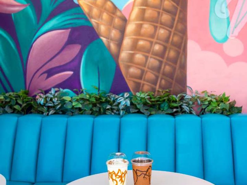 A vibrant seating area featuring a bright blue built-in banquette and a colorful ice cream themed mural wall.