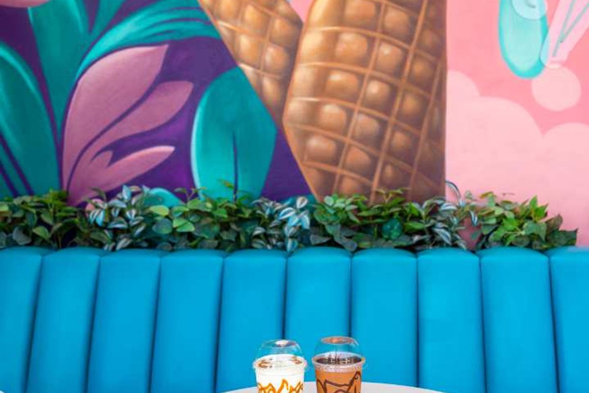 A vibrant seating area featuring a bright blue built-in banquette and a colorful ice cream themed mural wall.