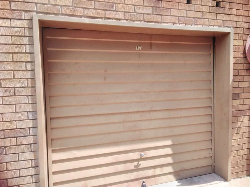 A standard single garage unit featuring a sectional door set within a brick exterior wall.