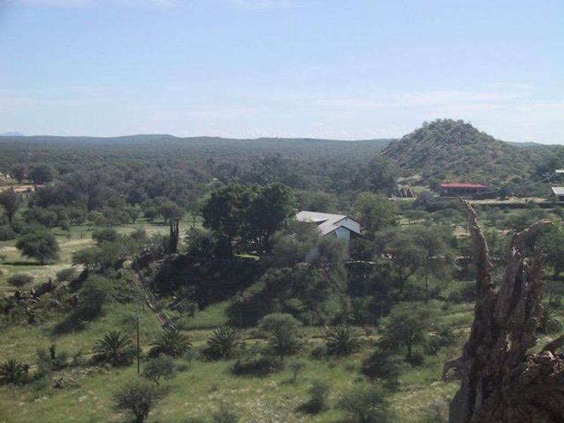 A wide-angle landscape view showcasing the surrounding natural terrain, vegetation, and distant hills from an elevated perspective.