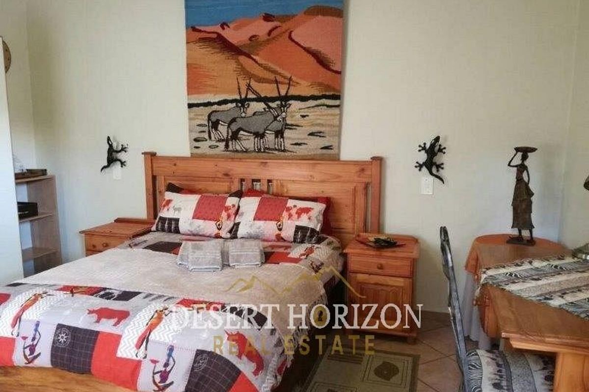 A bedroom featuring tiled flooring and neutral wall finishes, providing a functional space for guests.