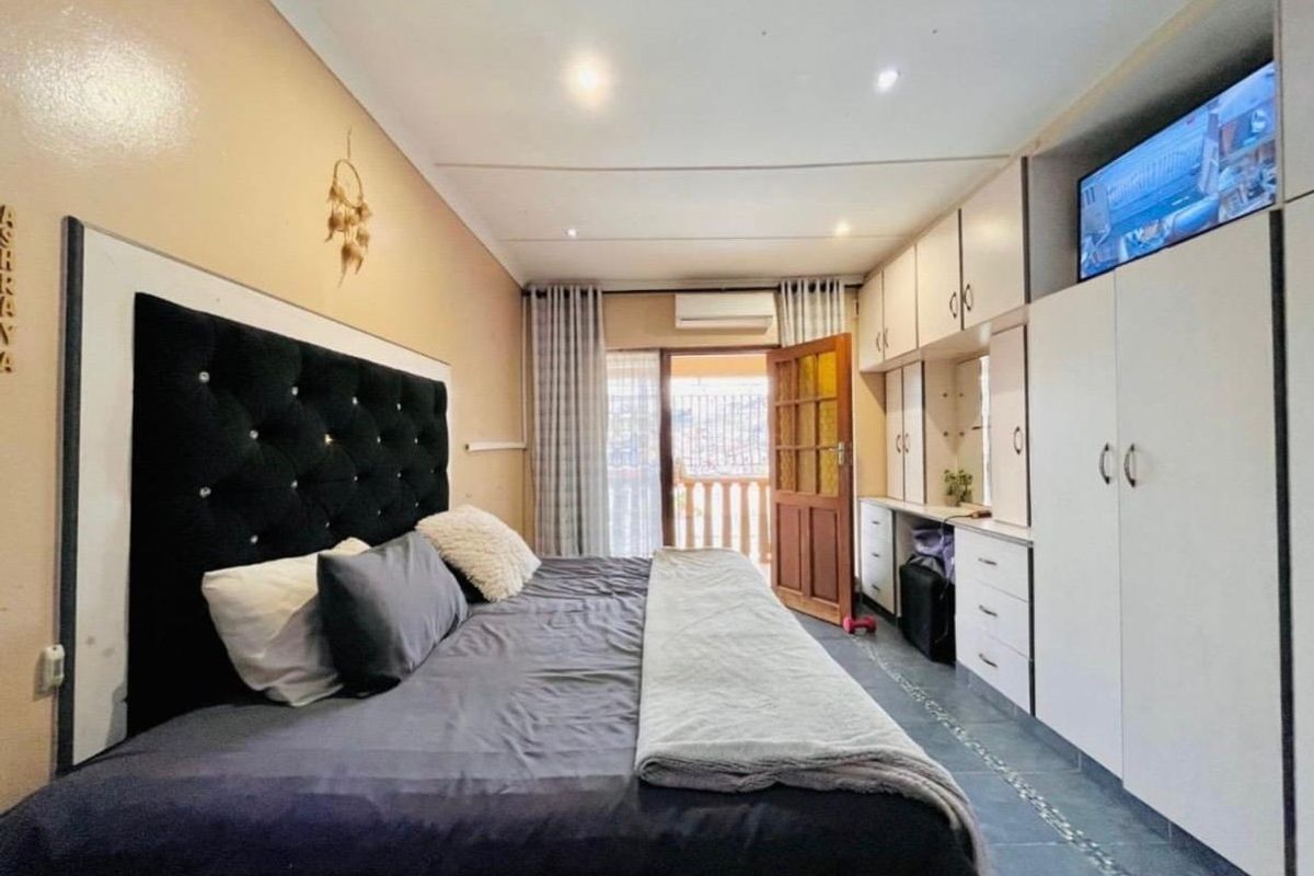 A bedroom featuring built-in cabinetry, tiled flooring, recessed lighting, and direct access to an outdoor balcony area.
