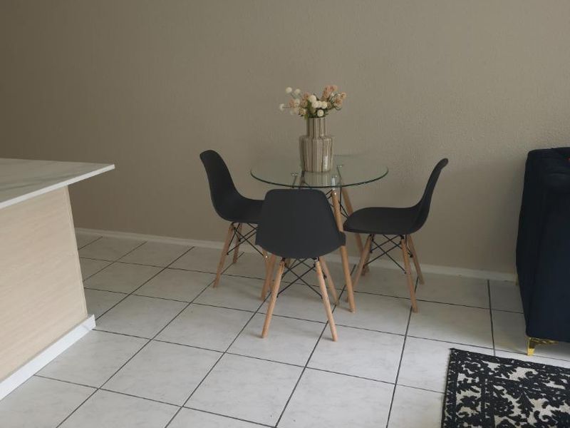 Open plan living area featuring a kitchen island and neutral ceramic floor tiles, providing a versatile space for dining and relaxation.