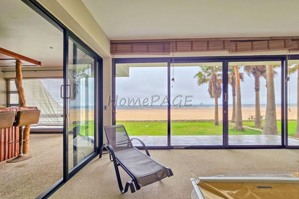 Spacious living area featuring large sliding glass doors that provide seamless indoor-outdoor flow and expansive ocean views.