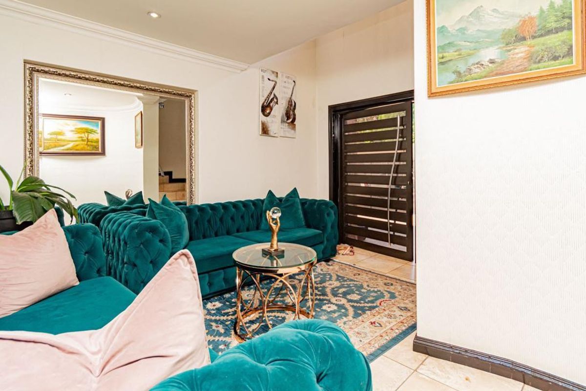 A well-maintained living room featuring tiled flooring, recessed downlighting, decorative coving, and a modern security entrance door.
