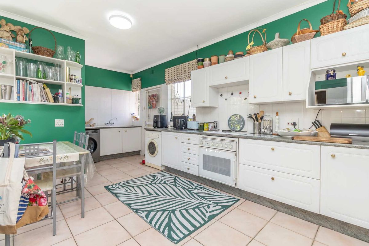A functional kitchen featuring white cabinetry, tiled flooring, a built-in oven, and a tiled backsplash, offering a practical layout for daily meal preparation.