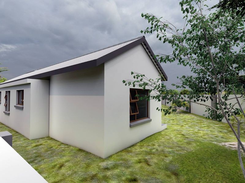 A view of the rear exterior of the house featuring a clean facade, pitched roof, and surrounding boundary wall in a landscaped garden setting.