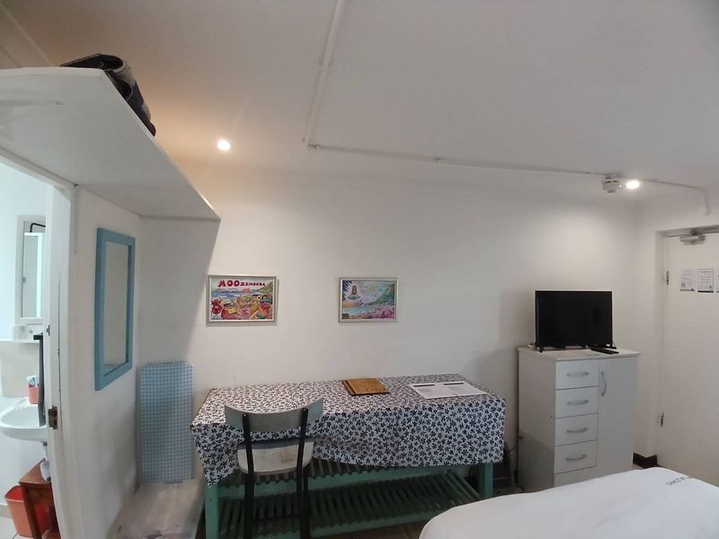 A compact bedroom featuring basic finishes, recessed lighting, and exposed surface-mounted electrical conduit along the ceiling.
